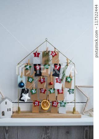 Number on craft paper notes with tasks before Christmas holidays. Female making kraft paper for handmade advent calendar Made with your own hands step by step DIY 117522444
