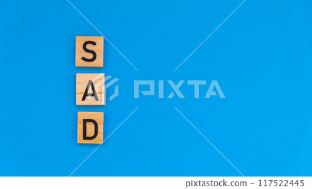 Seasonal affective disorder - text of wooden blocks on blue bright background. Concept of depression mood stress and anxiety. SAD 117522445
