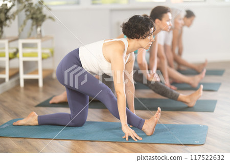 Adult woman doing pilates in group in studio 117522632