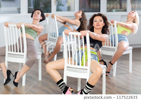 Women participant of dance group perform basic elements of heel dance in staggered manner. Development of female sexuality Women participant of dance group perform basic elements of heel dance in staggered manner. Development of female sexuality 117522635