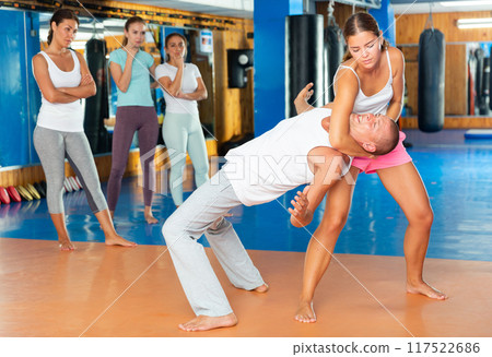 Young woman practicing self defence techniques with coach 117522686