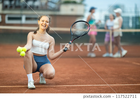 Young woman posing on tennis court 117522711