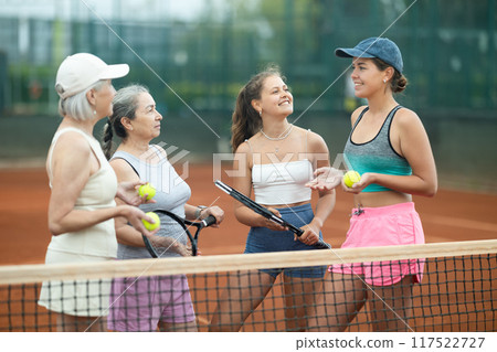 Group of women talking on tennis court Group of women talking on tennis court 117522727
