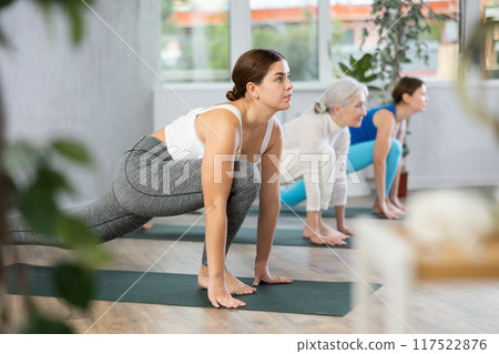 Young woman practicing pilates exercises in yoga studio 117522876