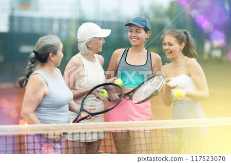 Group of women talking on tennis court 117523070
