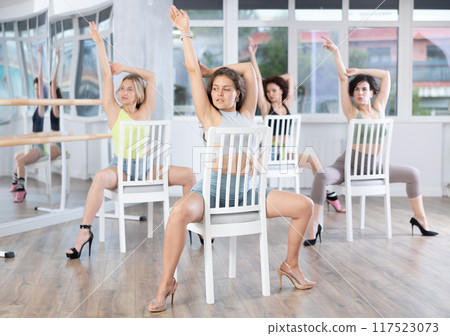 Sitting on chair, girl with long hair train to perform lap dance, interacting with imaginary partner Sitting on chair, girl with long hair train to perform lap dance, interacting with imaginary partner 117523073