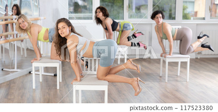 Young woman in high heels partaking in exotic chair dance class 117523380
