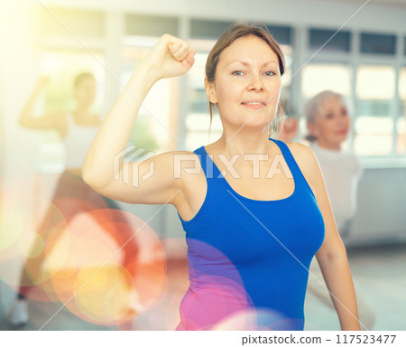 Adult woman doing fitness in fitness studio Adult woman doing fitness in fitness studio 117523477