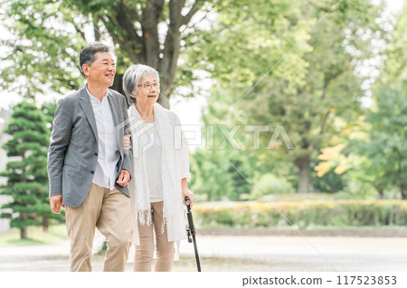 Japanese elderly couple walking while talking in the park (senior man and woman) Japanese elderly couple walking while talking in the park (senior man and woman) 117523853