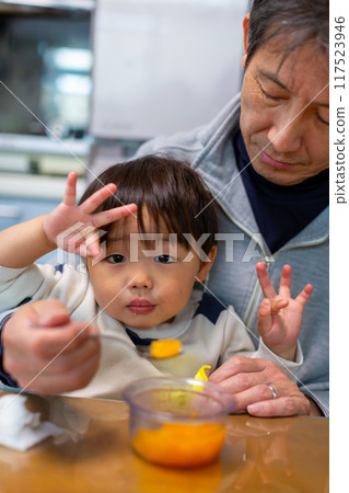 Toddler and grandfather eating dessert 117523946