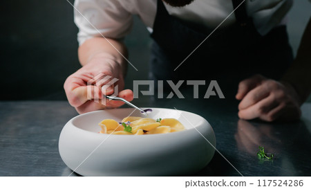 Refining The Plating Of A Ravioli Dish With Flowers 117524286