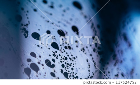 Foam flow. Bubble liquid. Defocused blue color fizzy texture chemical fluid wave on dark black abstract art background. 117524752