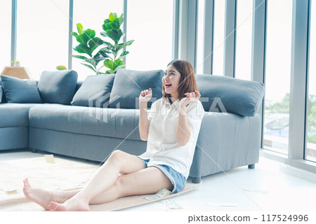 Happy young asian woman holding dollar money and throw in the air celebrate happiness dance wealth lottery money rain drop. Winner Success business woman throw cash flow Happy money smiling face 117524996