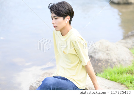 夏天，年輕人在水邊納涼聽音樂 117525433