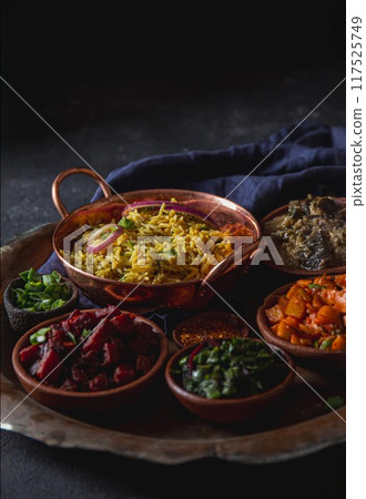 A plate featuring rice biryani and a variety of vegetarian Indian and Pakistani dishes. A plate featuring rice biryani and a variety of vegetarian Indian and Pakistani dishes. 117525749