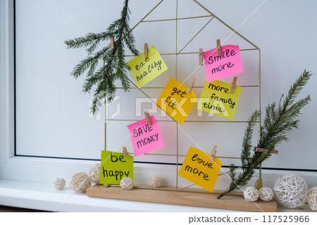 Action board new year's resolutions on colorful sticky notes. Making promises for new year, setting goals. Dream year 117525966