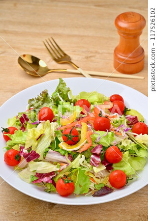 Plenty of vegetable salad, salad bowl, and green and yellow vegetables such as lettuce and tomatoes. 117526102