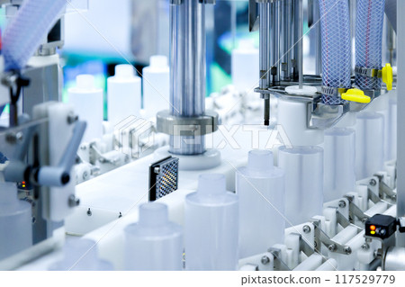 robot arm moving plastic bottle to conveyor belt of auto capping and labeling machine at cosmetic and skin care manufacturing. cosmetic industry and ai technology machinery concept. robot arm moving plastic bottle to conveyor belt of auto capping and labeling machine at cosmetic and skin care manufacturing. cosmetic industry and ai technology machinery concept. 117529779