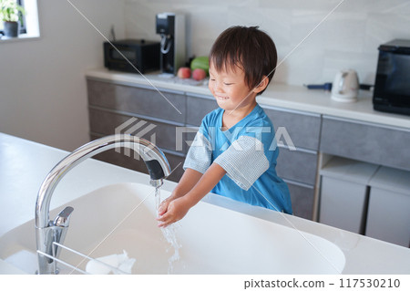 Child washing hands in kitchen Child washing hands in kitchen 117530210