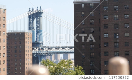 New York City Manhattan Bridge from Brooklyn Bridge. Red brown brick residential building windows. 117530822