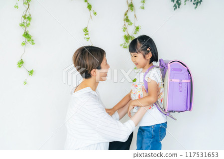 A girl and a mother carrying a school bag 117531653