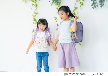 Two girls carrying school bags 117531656