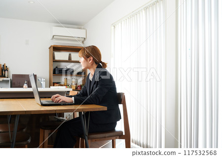 Woman talking on smartphone, suit, working from home 117532568