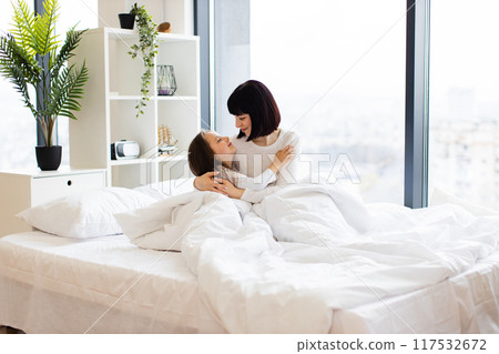 Mother and daughter hugging in cozy bed at home morning Mother and daughter hugging in cozy bed at home morning 117532672