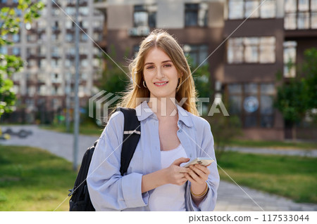 Walking young female using smartphone, modern city background 117533044