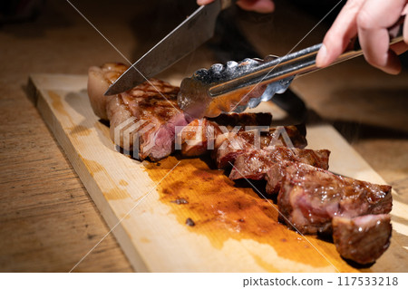 Hands cutting steak Hands cutting steak 117533218
