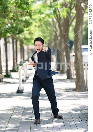 商人站在綠樹成蔭的大道上打太極拳 117534246
