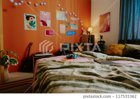 No people shot of modern teens bedroom interior with comfortable bed, posters, lights and painting on walls No people shot of modern teens bedroom interior with comfortable bed, posters, lights and painting on walls 117535362