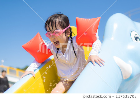 女孩在游泳池幻燈片上玩 117535705