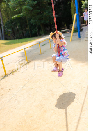 一個女孩在公園的泰山繩上玩 117535741