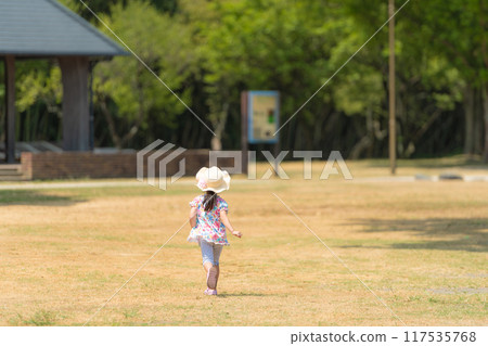Back view of a girl running in the park Back view of a girl running in the park 117535768