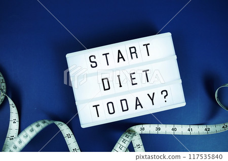 Start diet today? letterboard text on LED Lightbox and Measuring tape on blue background, Healthcare concept Start diet today? letterboard text on LED Lightbox and Measuring tape on blue background, Healthcare concept 117535840