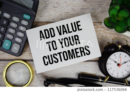 Add value to your customers text with calculator, magnifying glass and alarm clock on wooden background 117536066