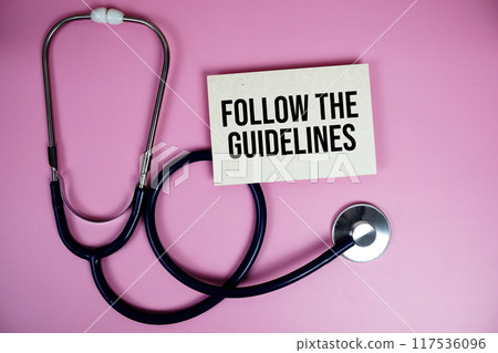 Follow the Guidelines text with stethoscope on pink background, Healthy and wellness concept 117536096