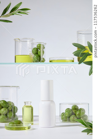 Cosmetic advertising with olive ingredient in laboratory concept, a white unbranded cosmetic bottle displayed in center. Olive oil is rich in antioxidants, vitamins A, E, and essential fatty acids Cosmetic advertising with olive ingredient in laboratory concept, a white unbranded cosmetic bottle displayed in center. Olive oil is rich in antioxidants, vitamins A, E, and essential fatty acids 117536262