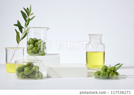 Presentation stage with blank platform for cosmetic product advertising, which made from olive, from front angle shot over white background. Olive oil help promoting a radiant and youthful complexion Presentation stage with blank platform for cosmetic product advertising, which made from olive, from front angle shot over white background. Olive oil help promoting a radiant and youthful complexion 117536271