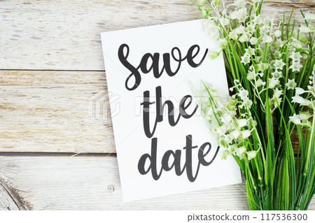 Save the Date text with flowers decoration on white wooden background 117536300