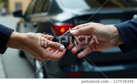 Man woman gets the car key from seller - satisfied - trade closed - new car in the background. Concept of buying a vehicle, auto business. 117536395