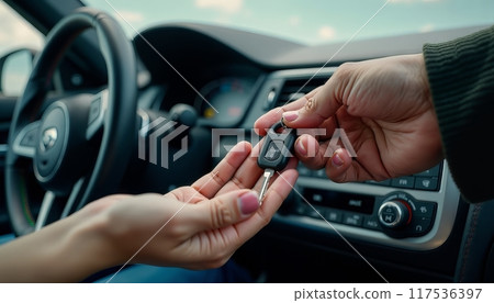 Man woman gets the car key from seller - satisfied - trade closed - new car in the background. Concept of buying a vehicle, auto business. 117536397