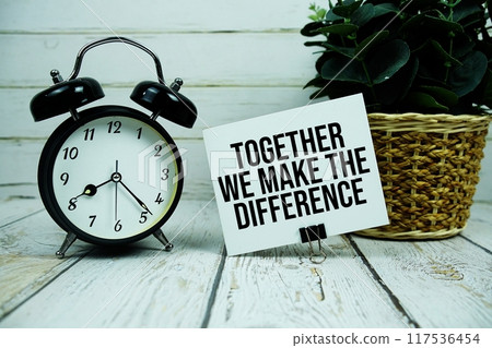 Together We Make The Difference text on paper card with alarm clock on wooden background Together We Make The Difference text on paper card with alarm clock on wooden background 117536454