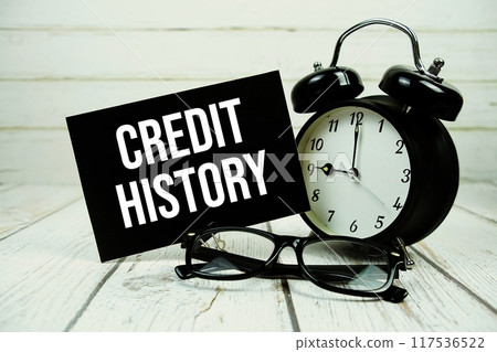 Credit History text on paper card with alarm clock on wooden background Credit History text on paper card with alarm clock on wooden background 117536522