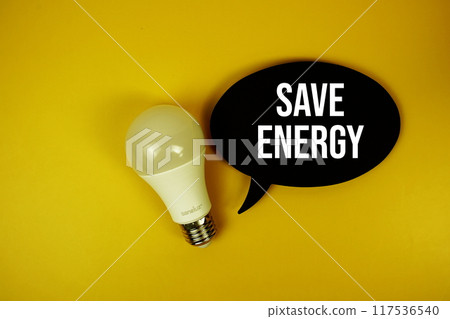 Save Energy text on speech bubble with light bulb top view on yellow background Save Energy text on speech bubble with light bulb top view on yellow background 117536540