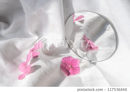 Pink hydrangea flowers and a mirror on a white background of soft 117536848
