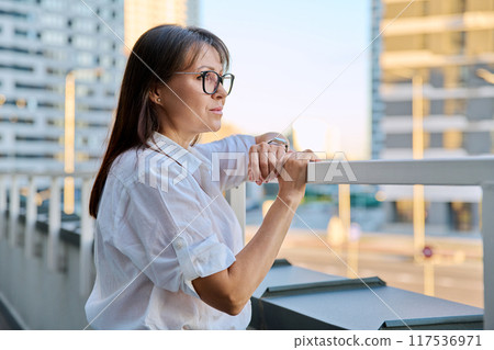 Portrait of middle-aged confident woman posing outdoors, profile views 117536971
