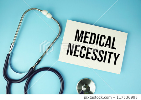 Medical Necessity text on paper card with stethoscope top view on blue background Medical Necessity text on paper card with stethoscope top view on blue background 117536993