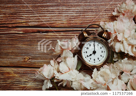 Space copy background with alarm clock and flower decoration on wooden background 117537166